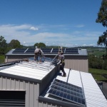 Two men installing solar on a shed roof