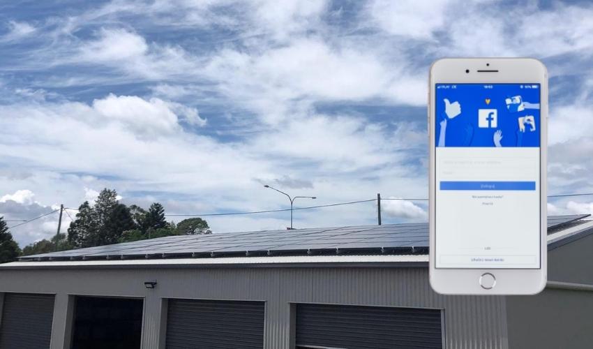 Phone with Facebook page in front of solar panel on shed