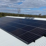 Clean black solar installation with cloudy sky background